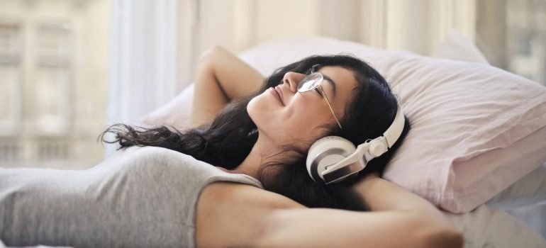 a woman listening to music while laying in bed
