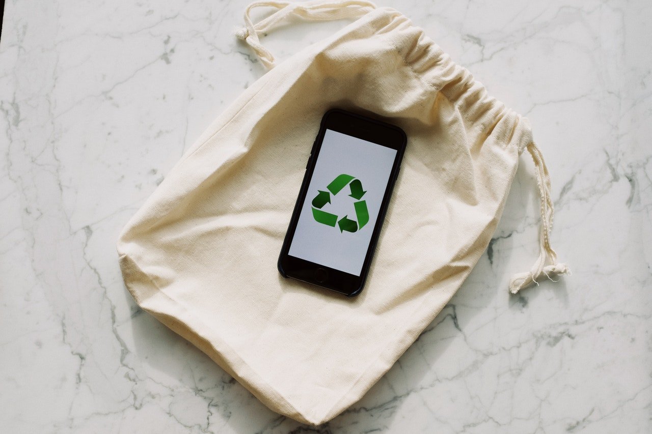 A phone, with a recycle sign, on an eco bag