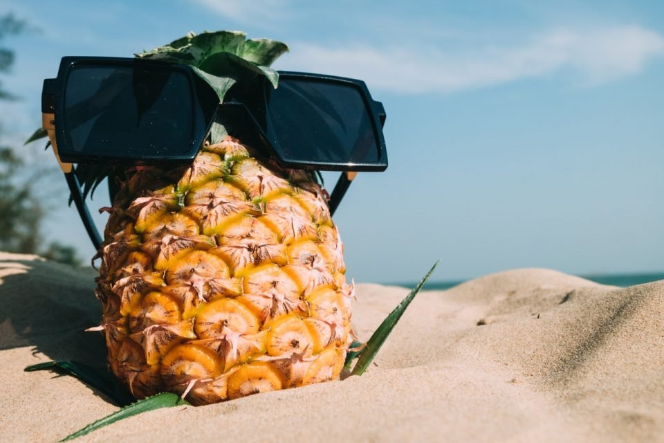 Pineapple and glasses on the beach