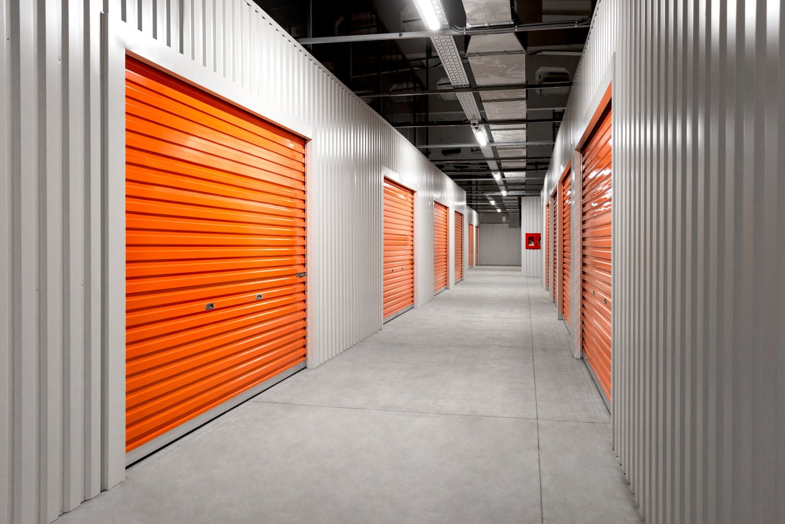 A double row of orange doors to storage units.