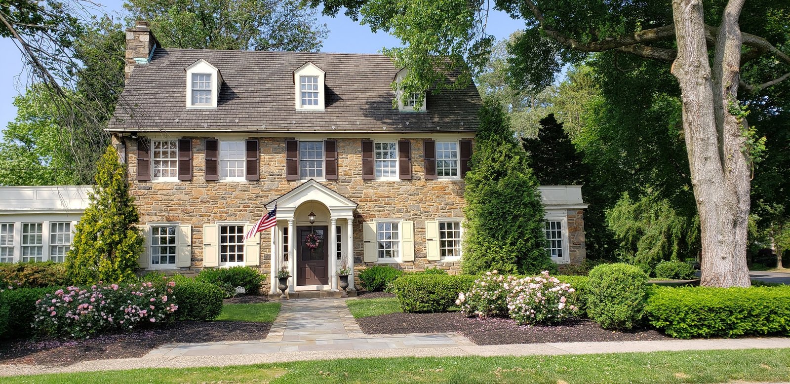 Large, white family house with a meadow in front.
