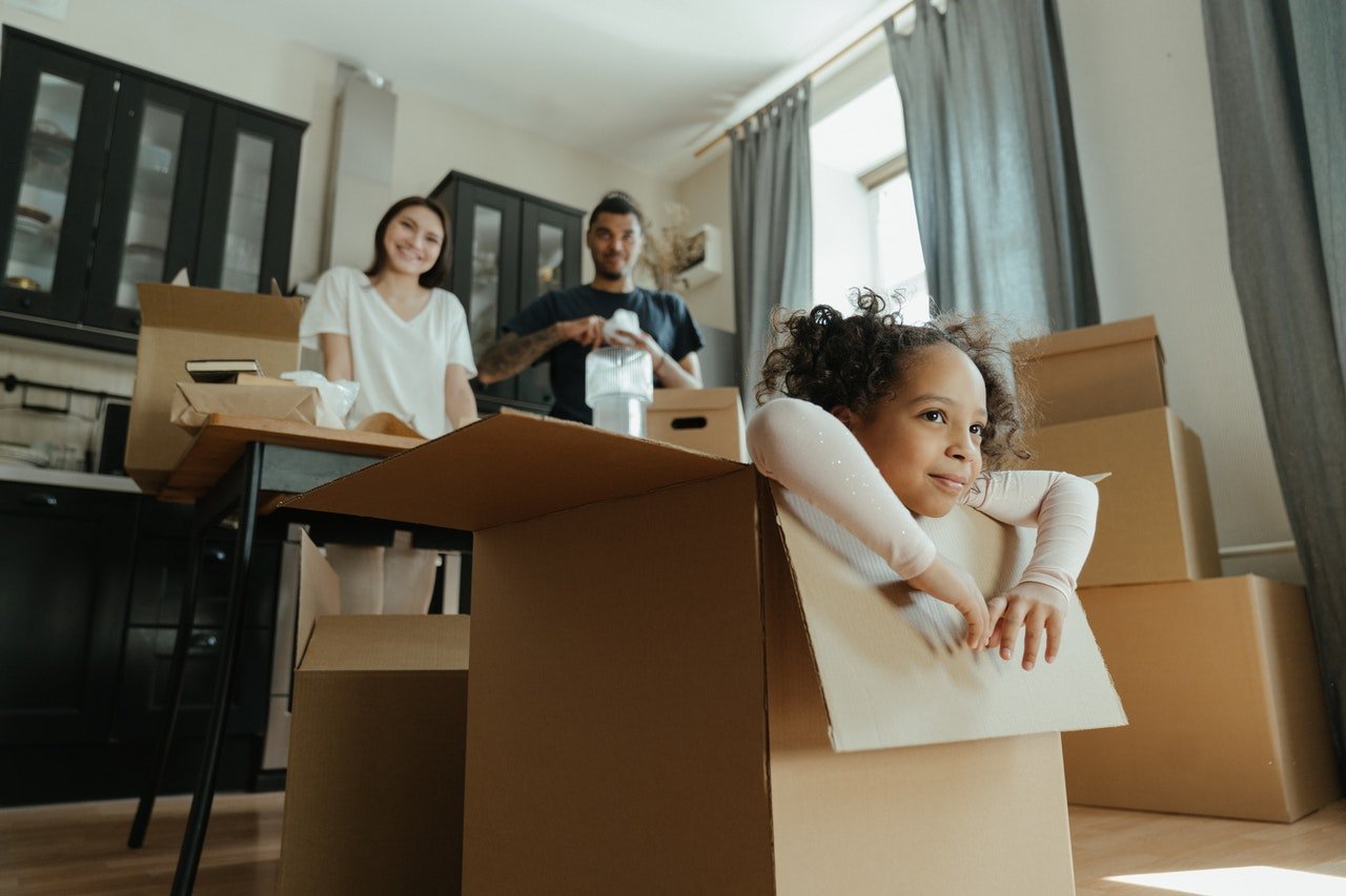 A girl in a moving box helps unpack after a move