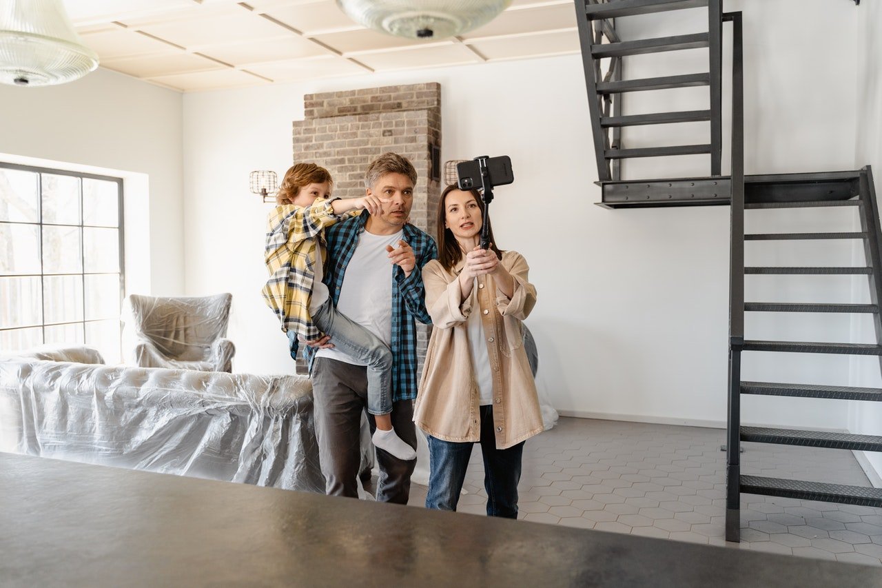 Parents and a child taking selfie during move preparation.