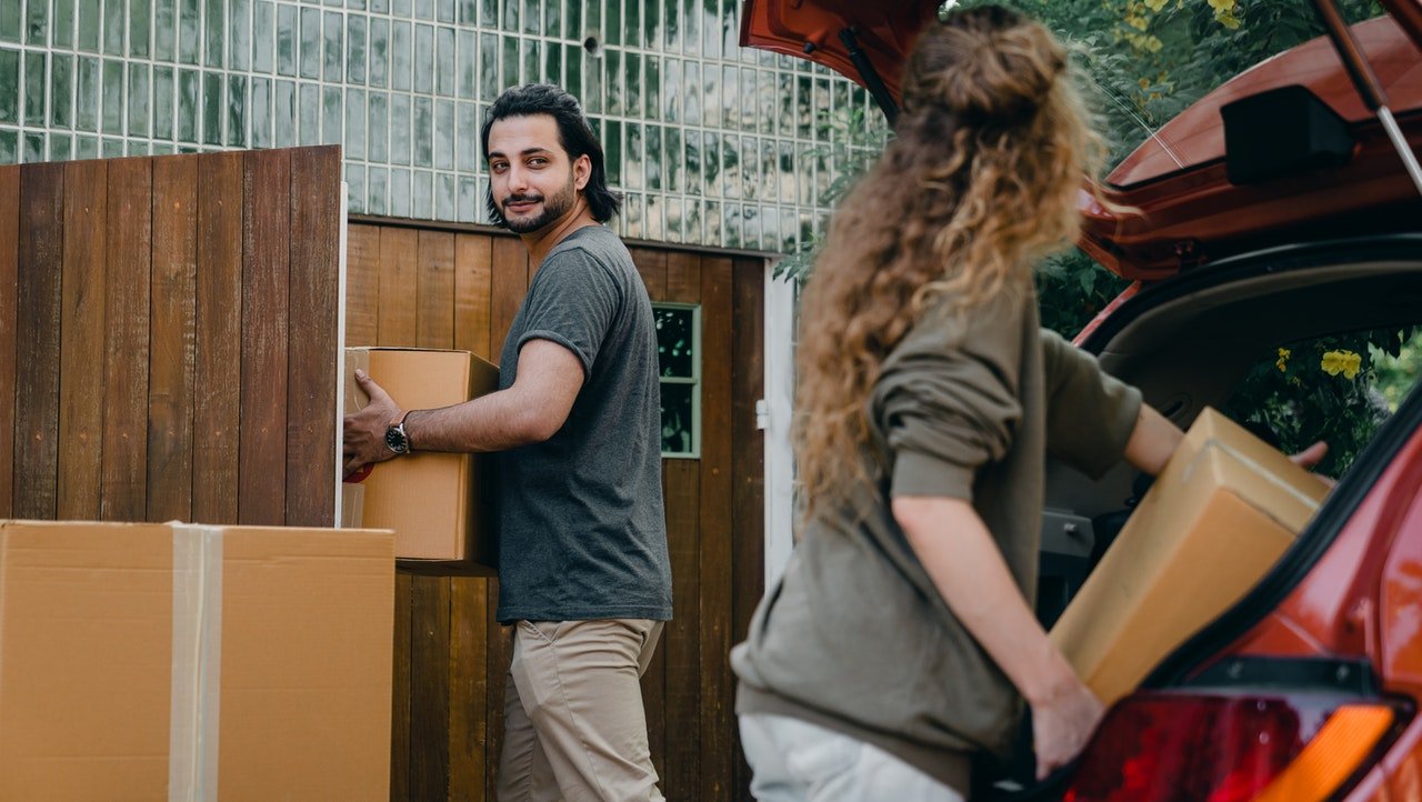Couple unloading boxes from a car