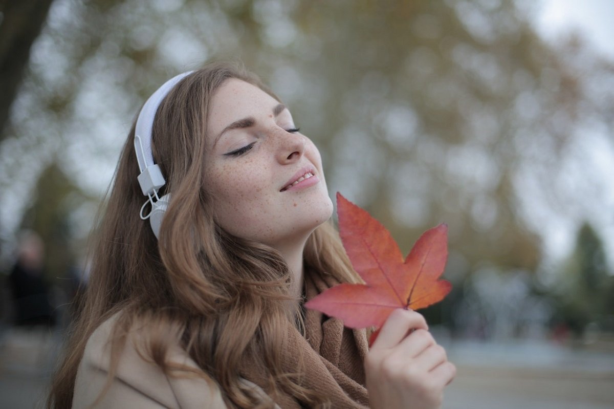 woman with headphones and a leaf