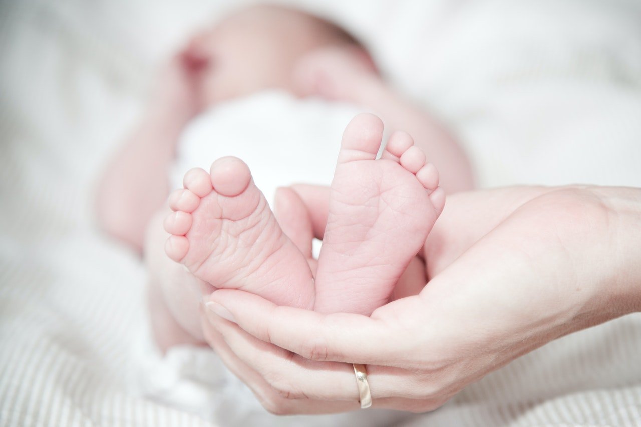 Newborn's feet in a hand of an adult