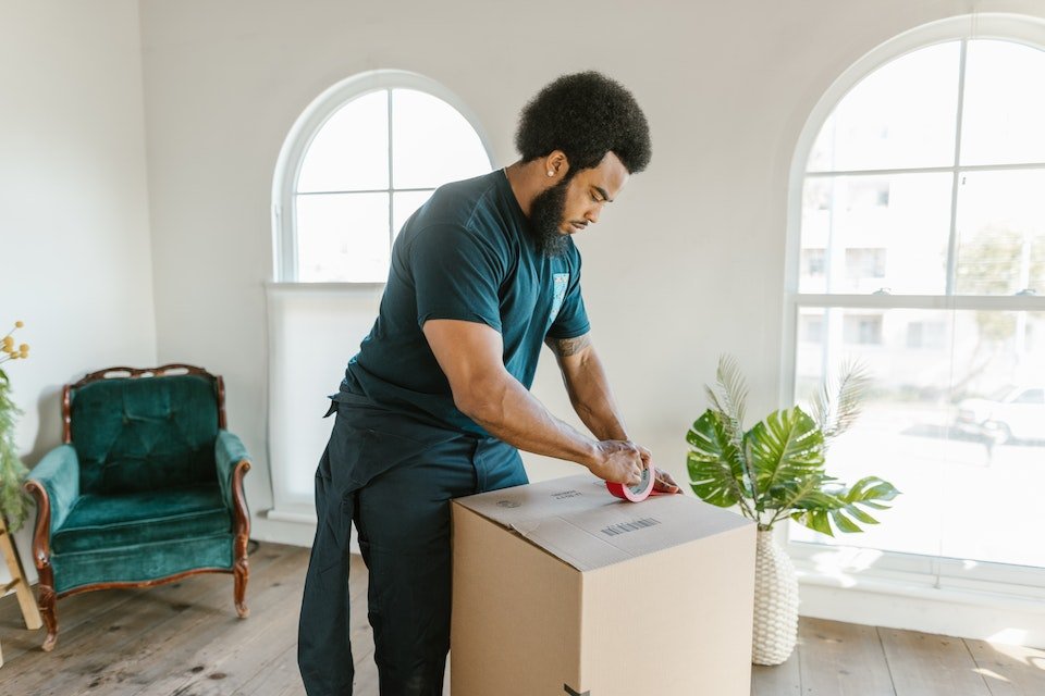 A pro mover packing a box;