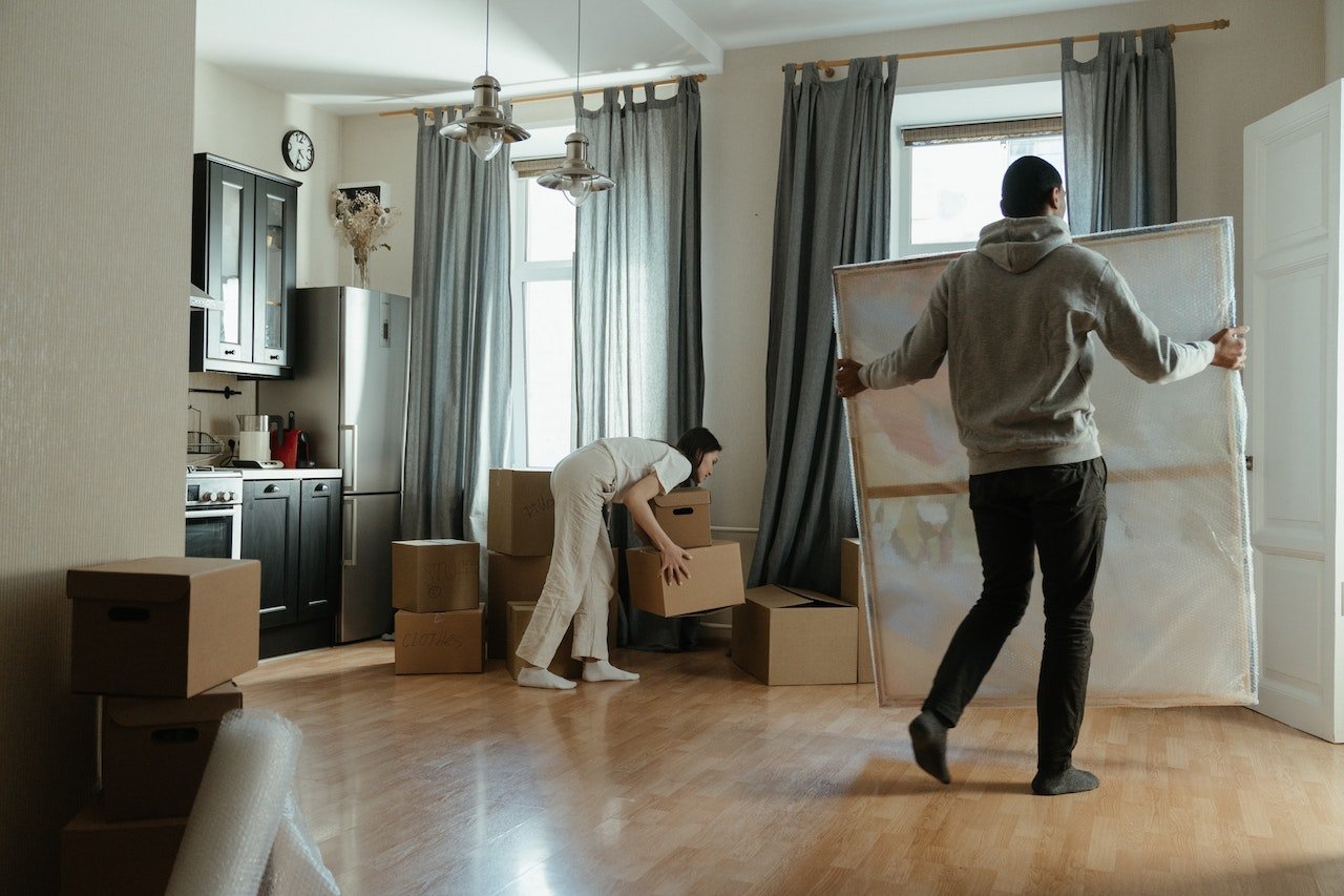 a young man and a young woman carefully picking items to avoid injuries on a moving day