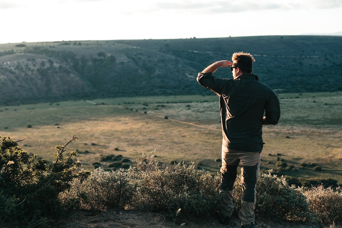 traveler standing on hilltop in daytime