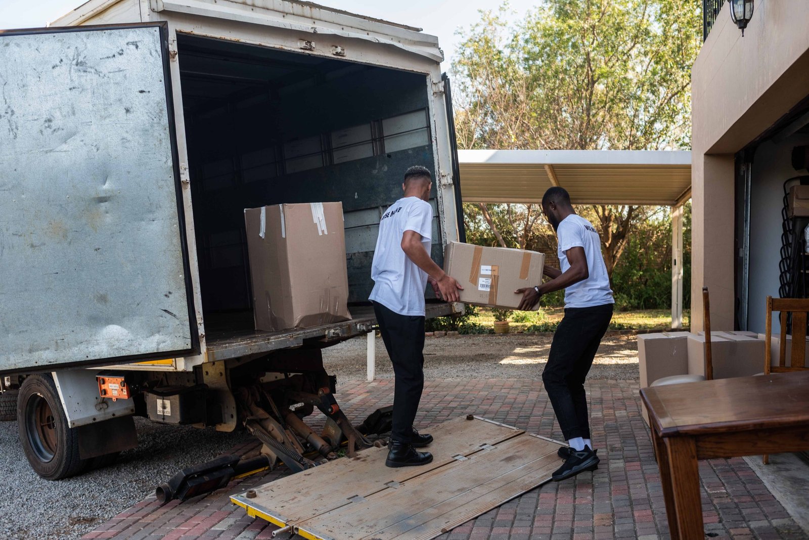 Two men moving boxes out of the van