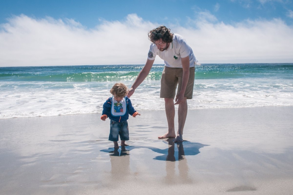 A man and a small boy on the beach after moving to Monterey with family