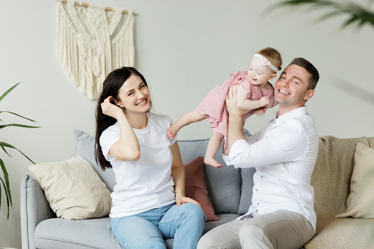 Happy family with a newborn in new home talking about common mistakes people make when moving with a newborn