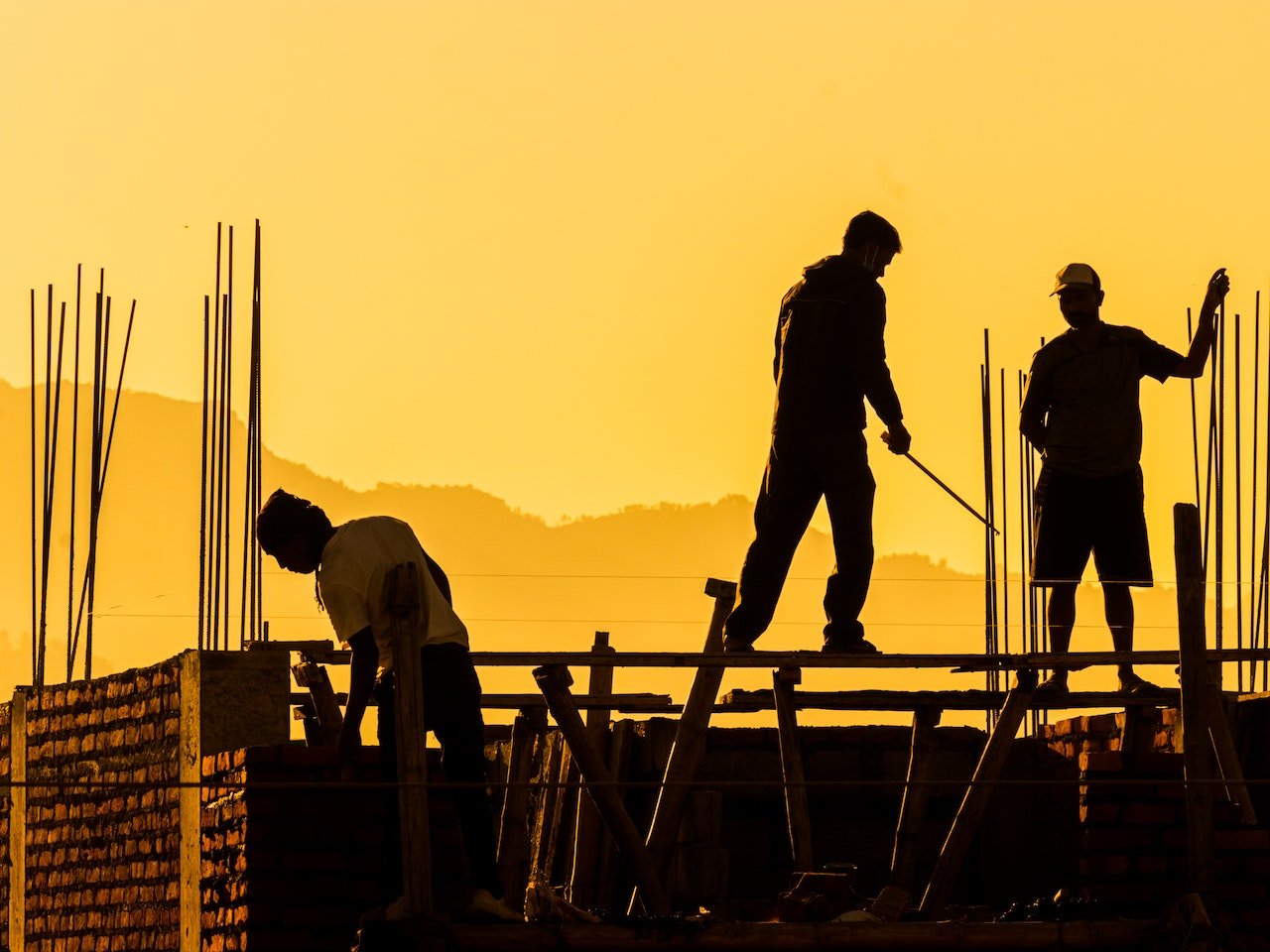 men working on building construction at sunset