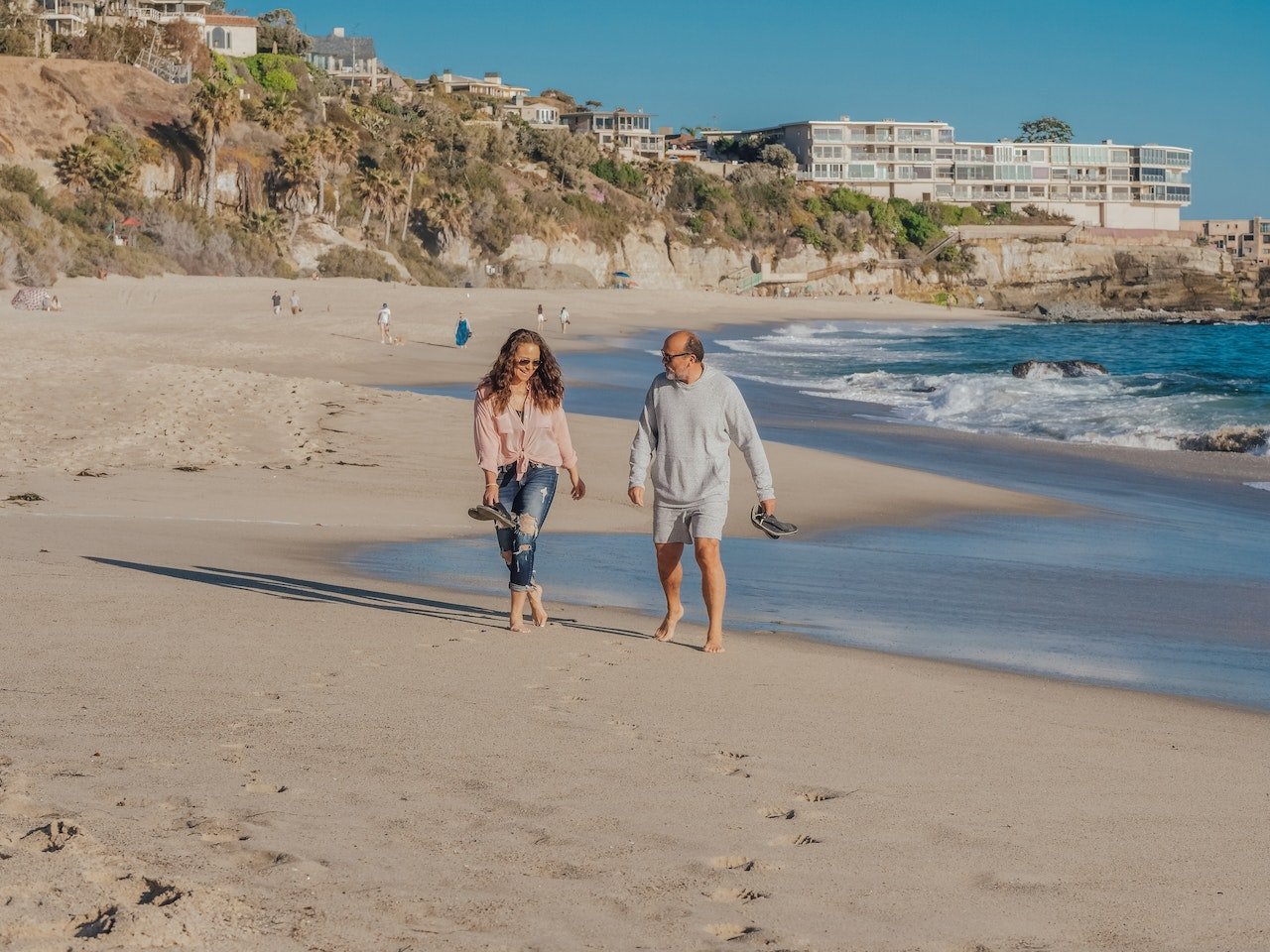 a man and a woman walking down the beach