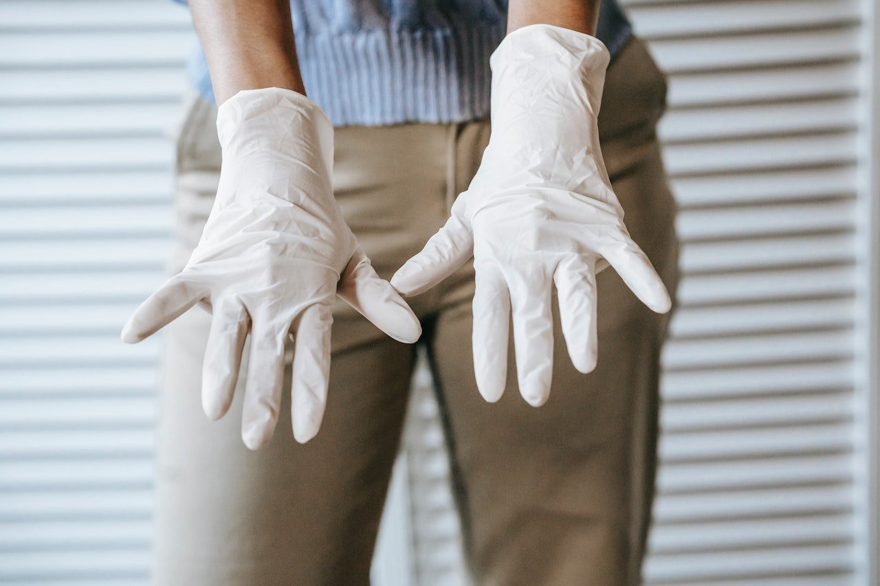 a woman showing hands with white gloves