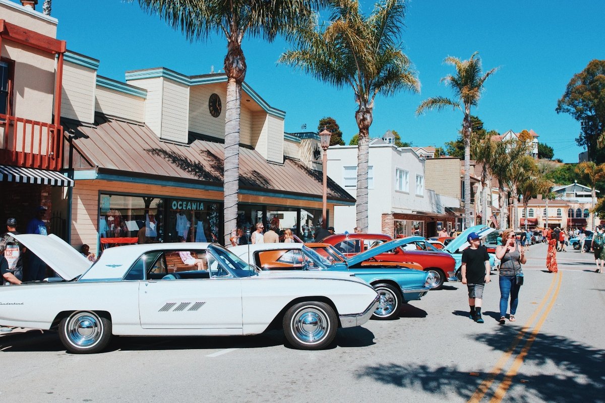 white coupe in the street in front short houses