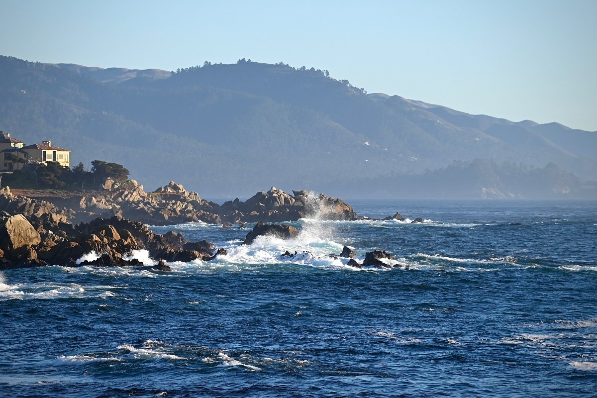 Waves crashing on rocks in the ocean during daytime in one of the ideal Monterey County locations for newlyweds