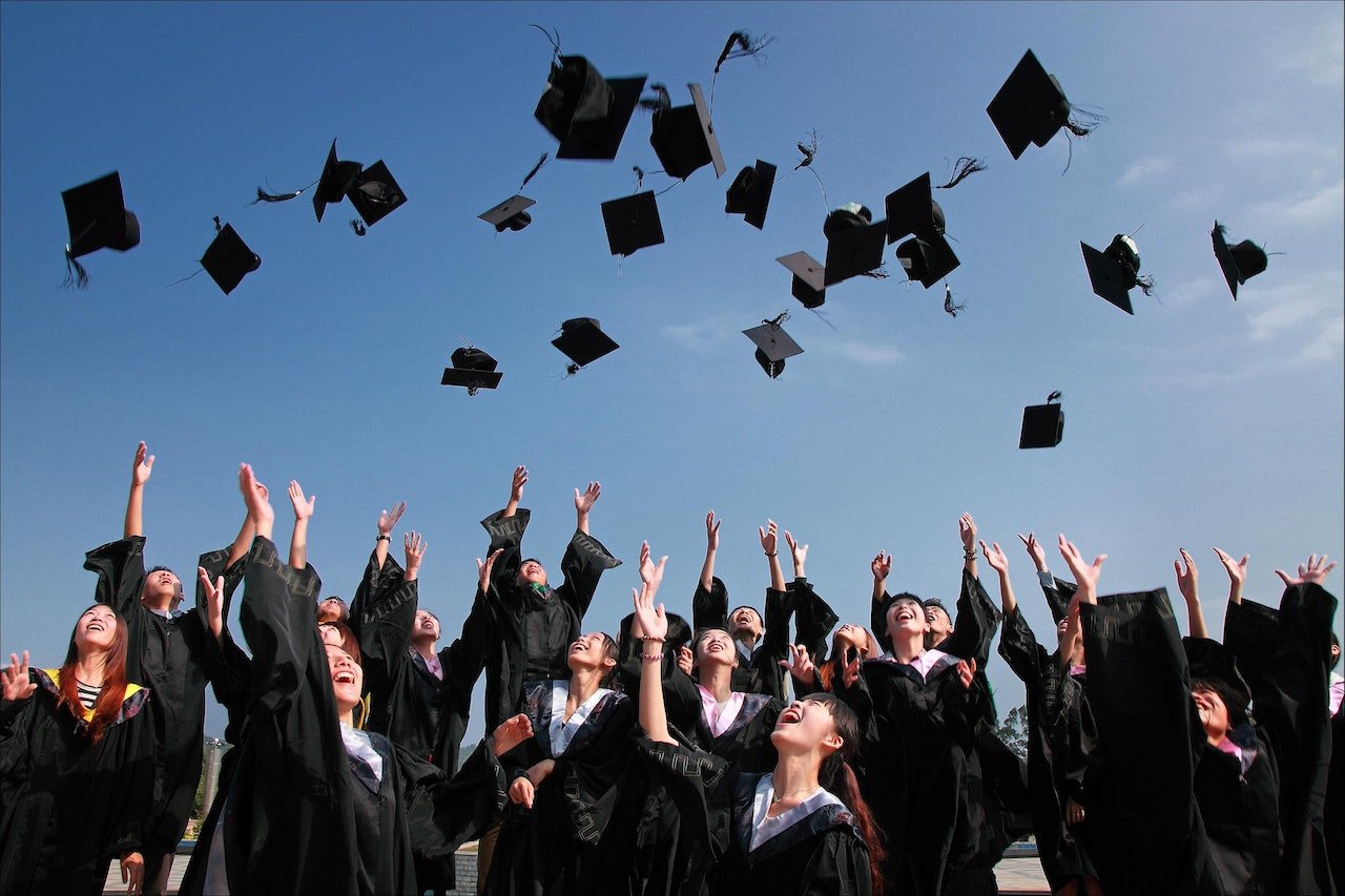 students throwing hats in the air and graduating after having read an extensive student guide to Gilroy