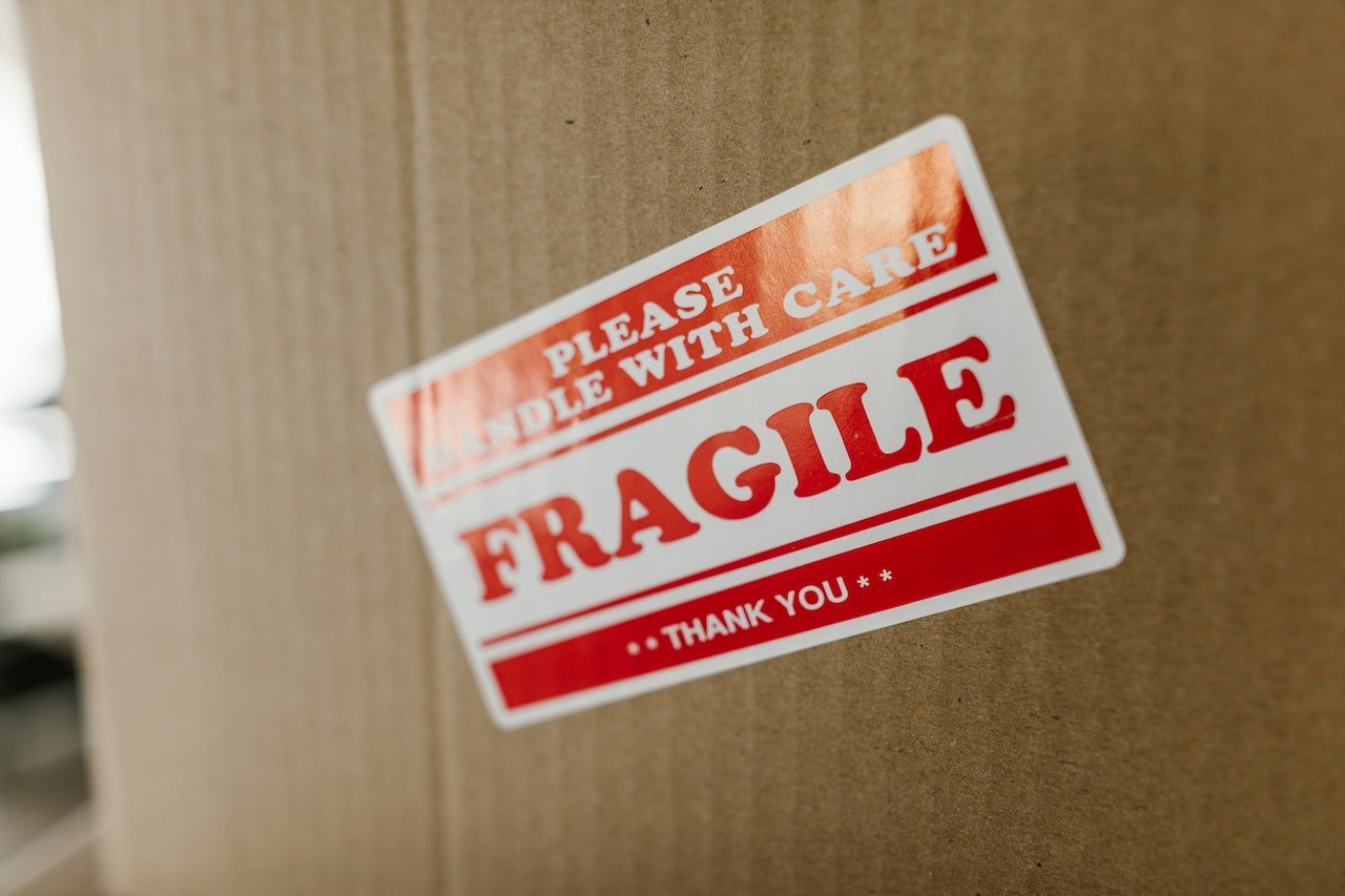 A box market with a sticker that says fragile symbolizing risks of moving valuables by yourself