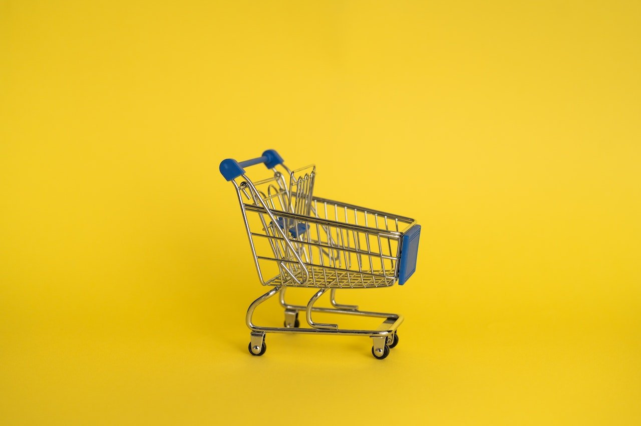a small shopping trolley on a yellow surface