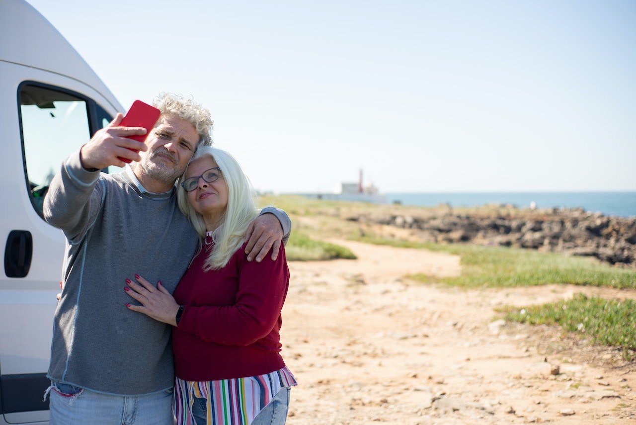 senior couple taking a selfie at the beach
