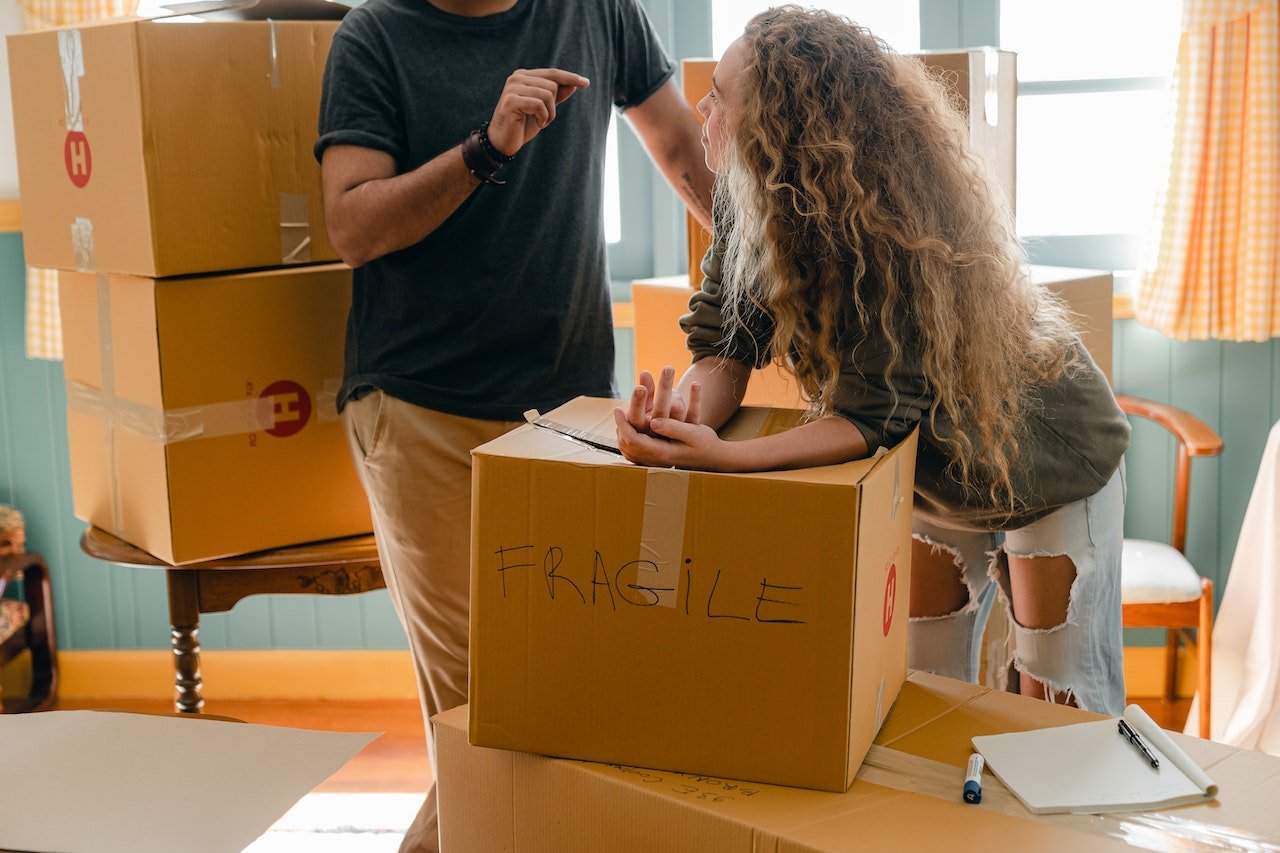 Woman leaning on a box labeled "FRAGILE"
