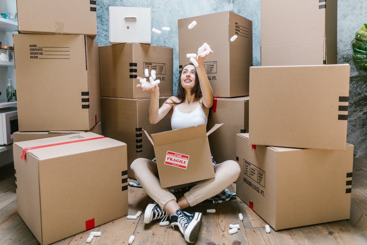 A woman sitting on the floor and playing with packing peanuts