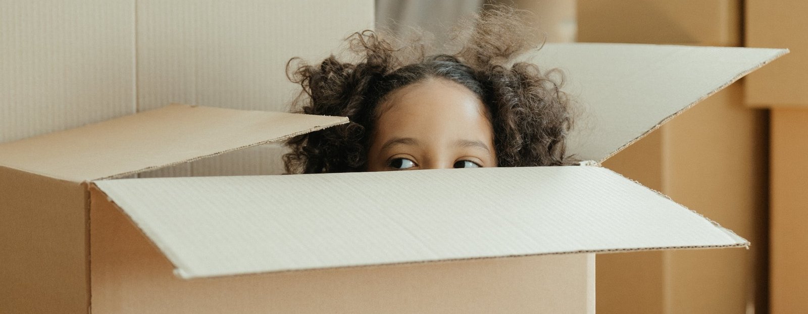 A girl hiding in a box.