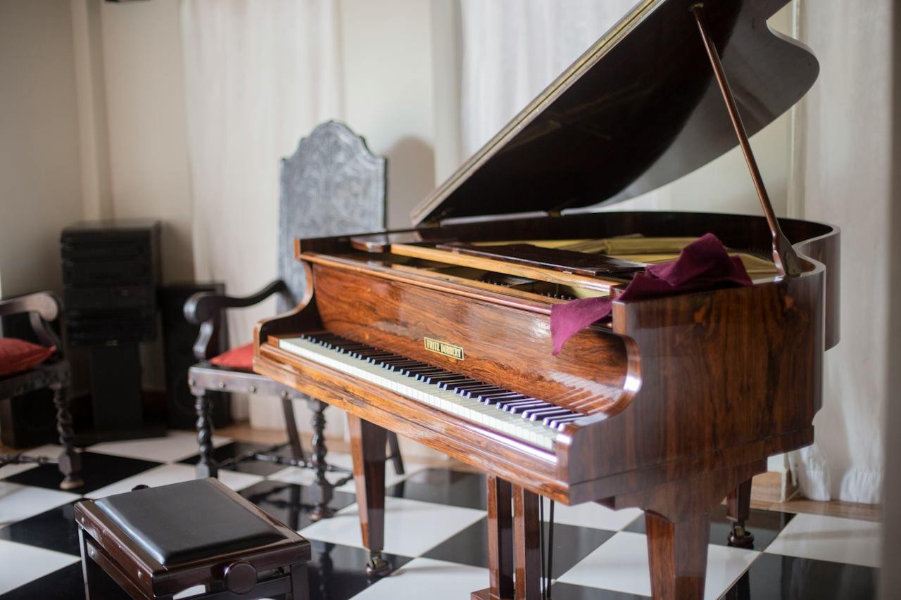a big brown wooden piano inside the house