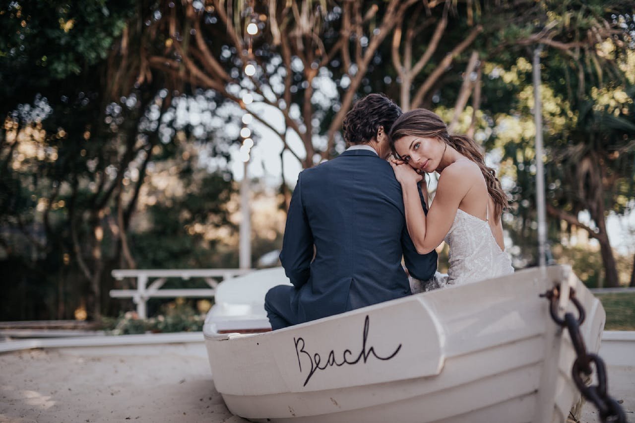 newlyweds sitting in a boat going to one of the ideal places in California for newlyweds