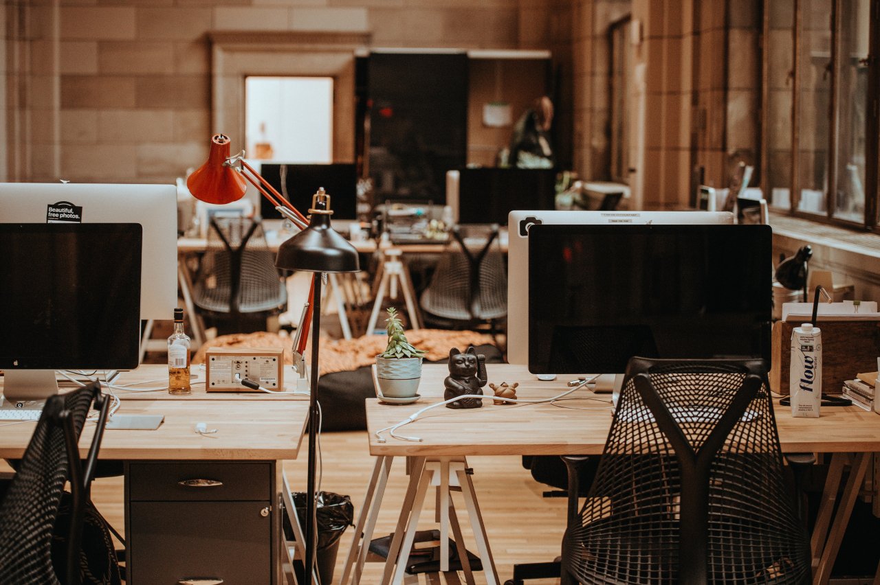 a picture of an office with computers on the desks