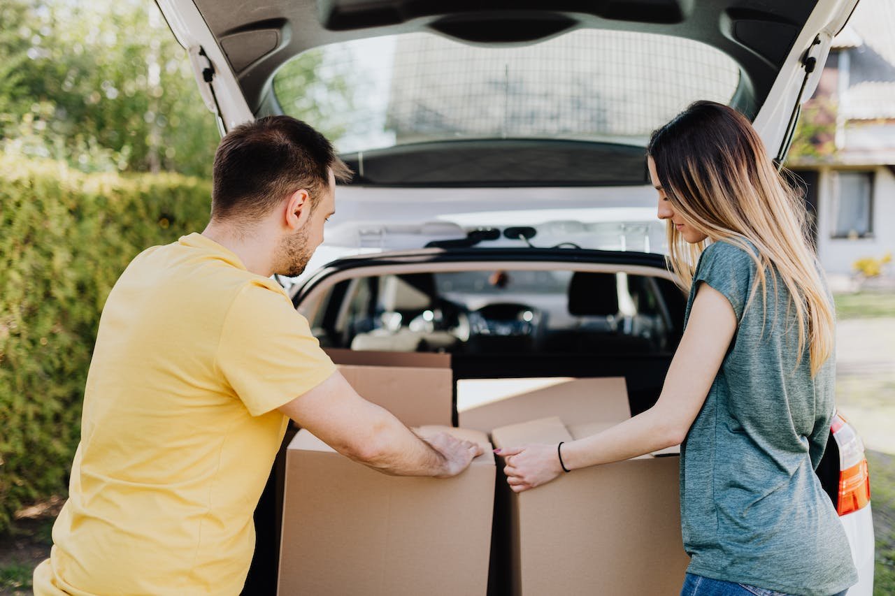 couple putting moving boxes into the car
