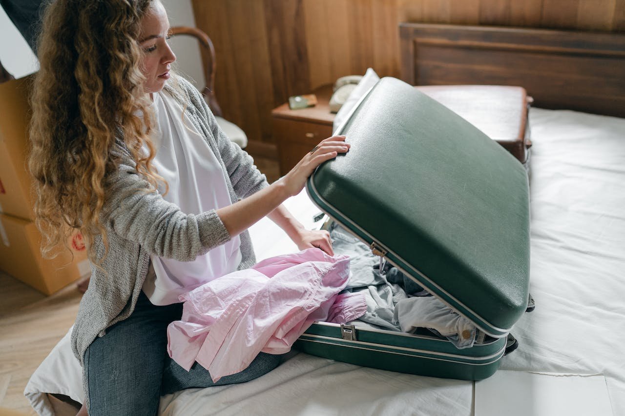 a woman packing a suitcase