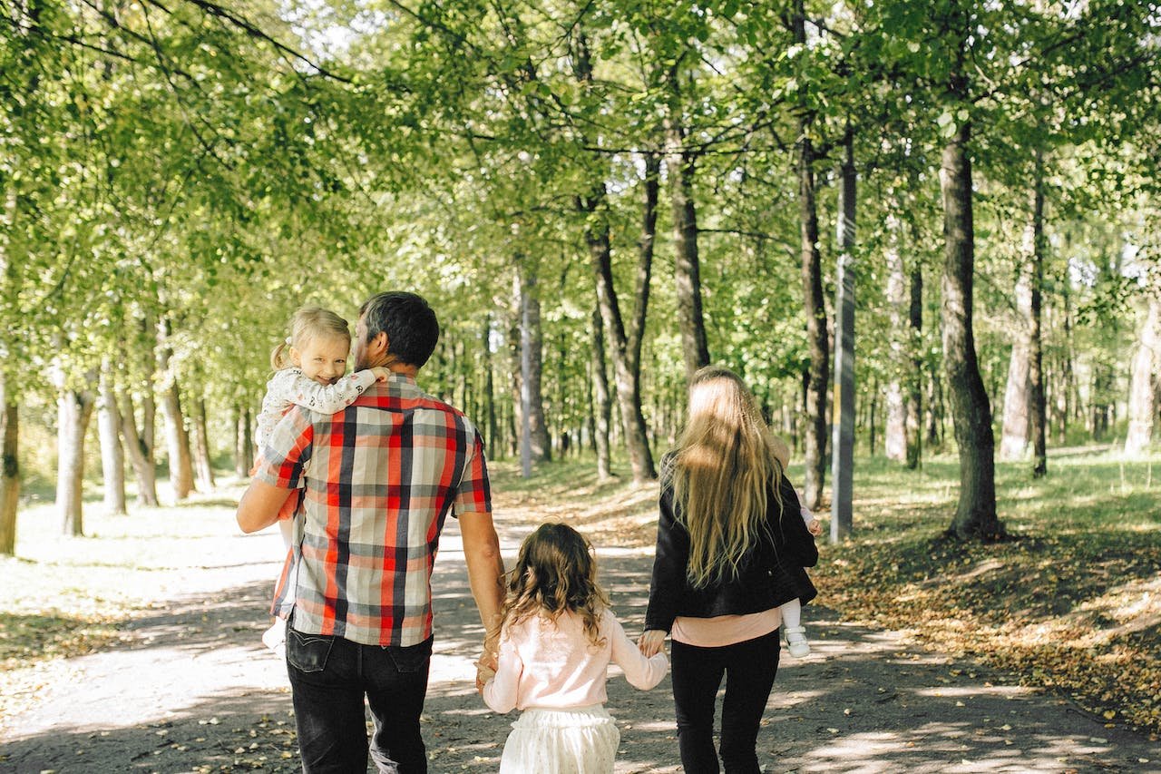 A family walking in a green park of one of the ideal places in California to grow up