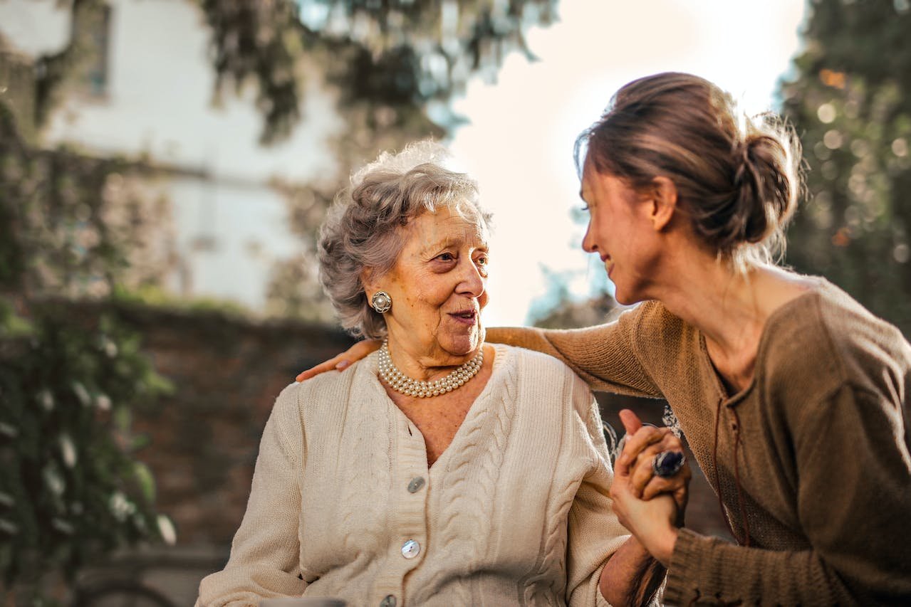 Older and younger woman smiling.