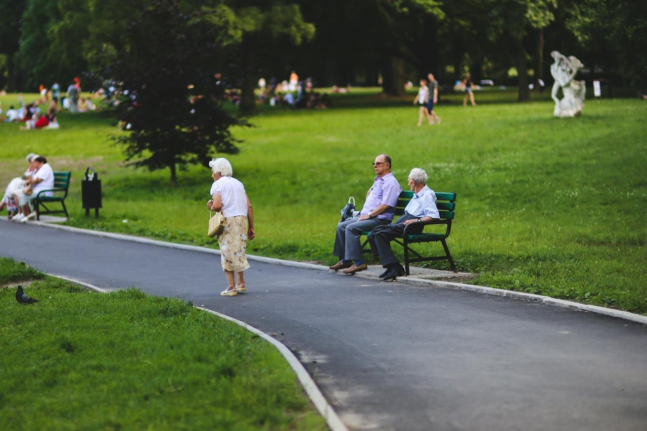 Woman walking and people sitting on the bench.