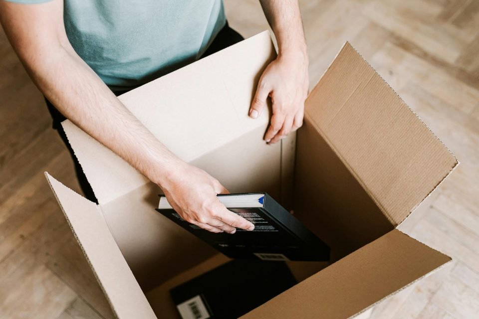 Man placing books into a moving box