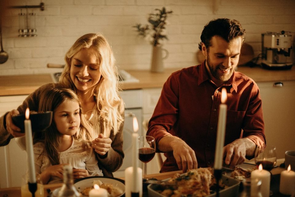 Parents at the dining table with their young daughter