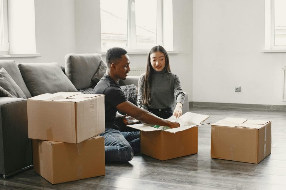 Couple packing moving boxes on the floor
