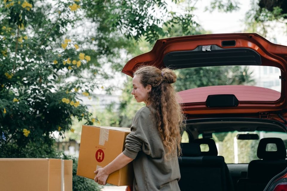 A woman taking some boxes out of the car