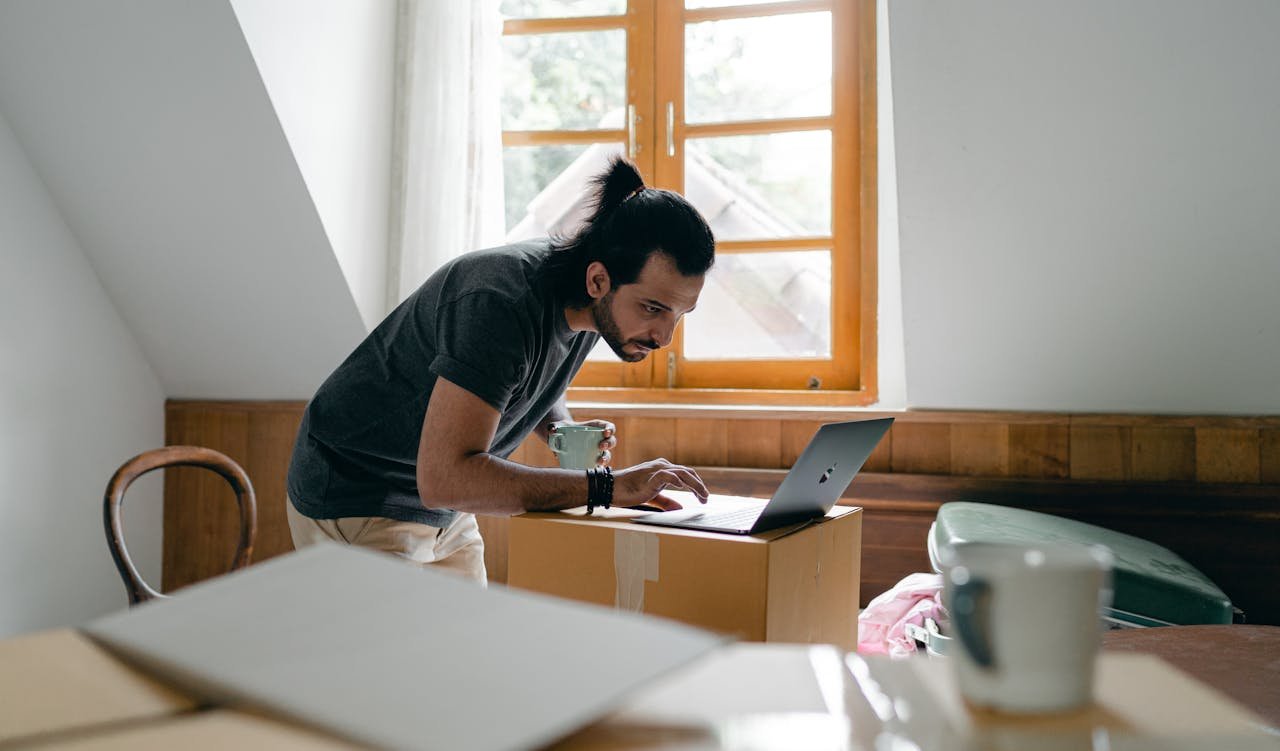 Man using laptop on carton box