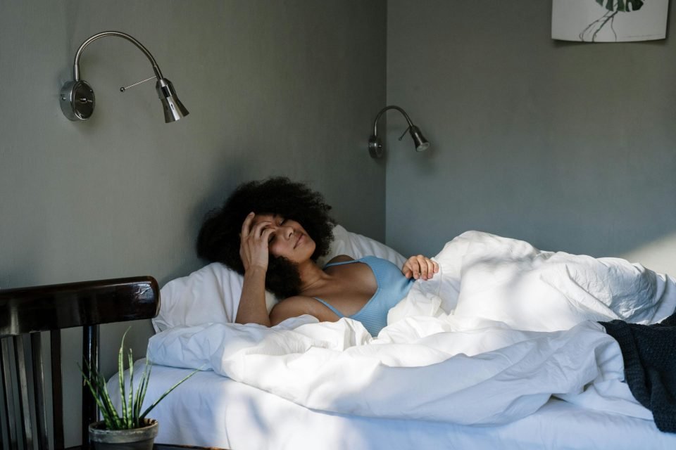 Girl with curly hair laying in bed